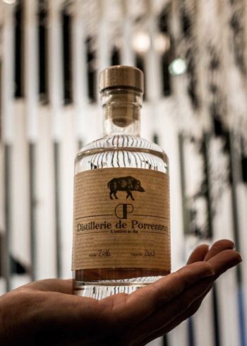 distillerie porrentruy bouteille dans la main